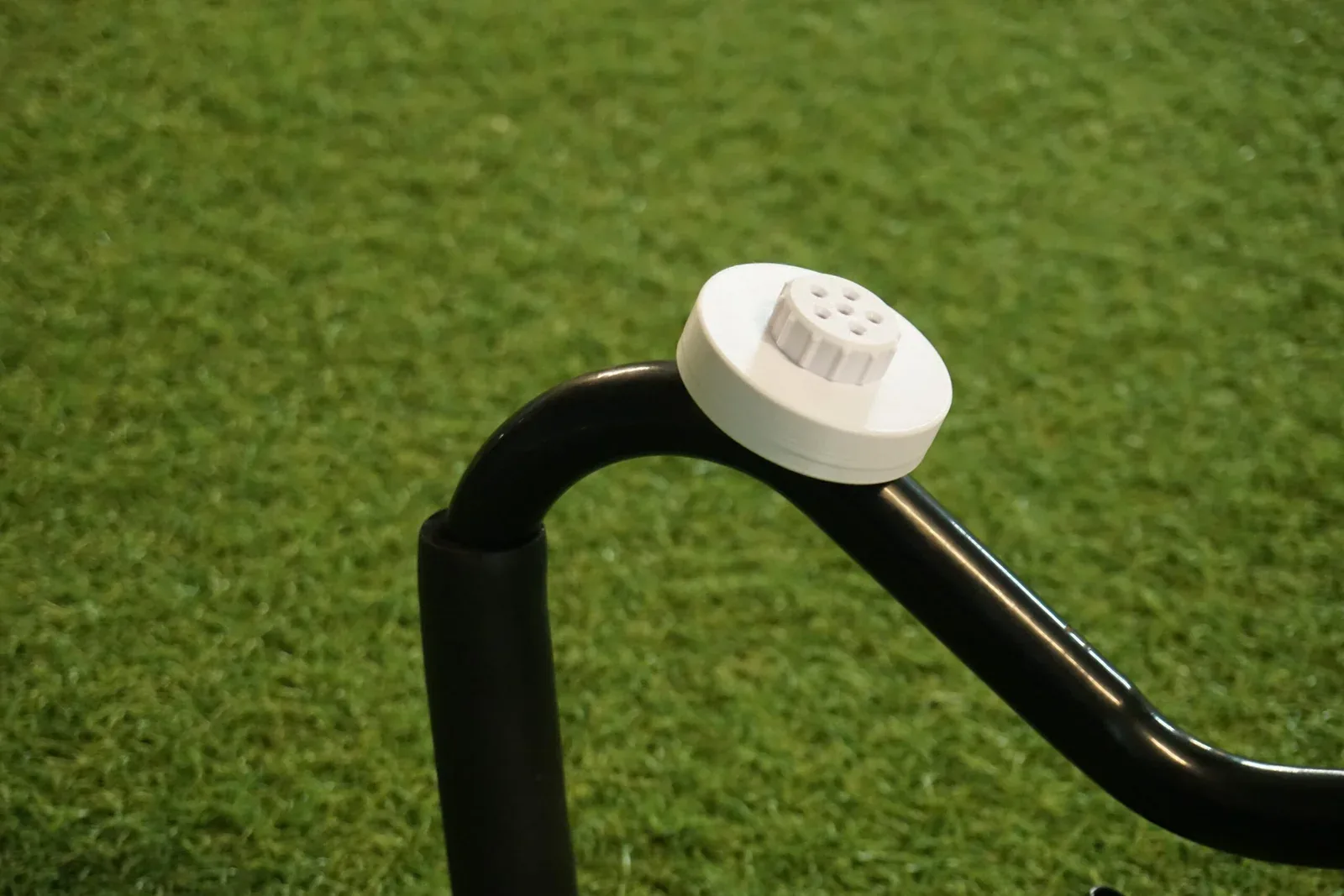 White scent container attached with a magnet on the end of a bent metal pipe