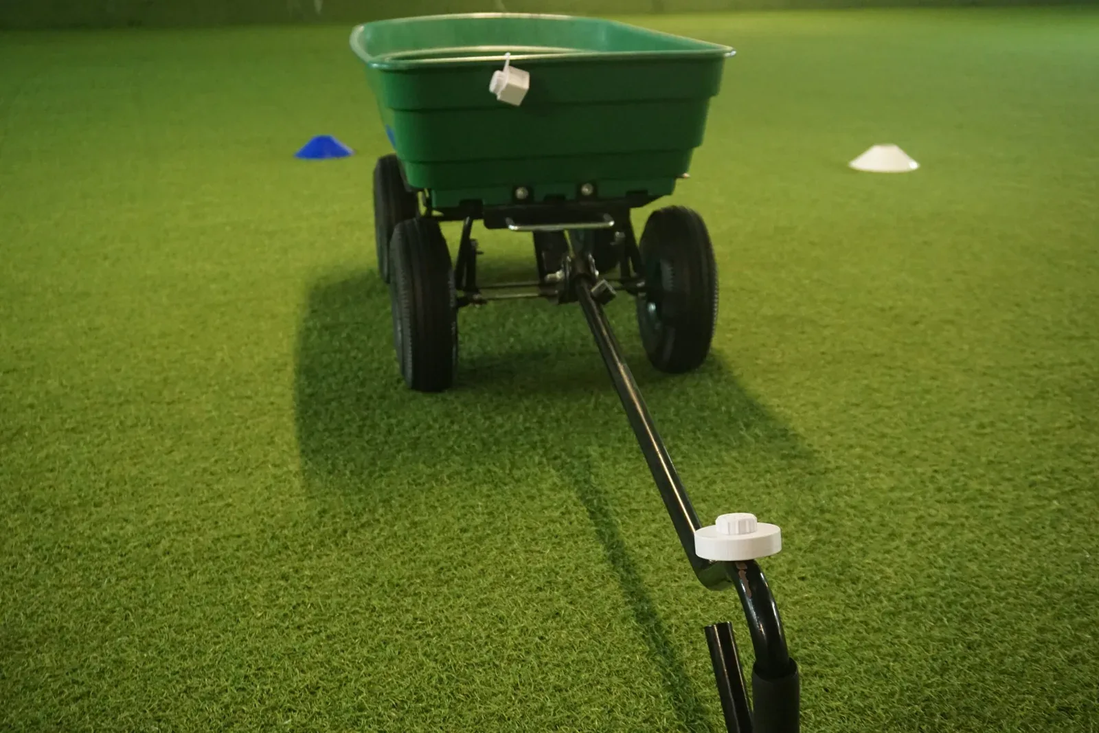 Garden wagon in the distance on artificial turf, with scent containers on the rim and tow bar